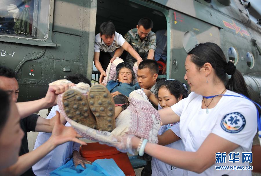 8月5日，醫護人員將一名通過直升機從震中轉運出來的傷員運下飛機。