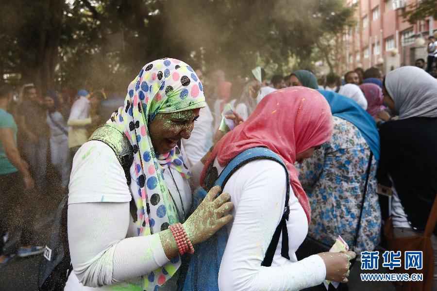 10月16日，在埃及首都開羅，兩名女青年在“彩色跑”活動中躲避人們拋撒的彩色粉末。