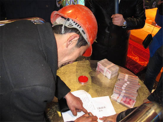 農民工在現場領取工資。