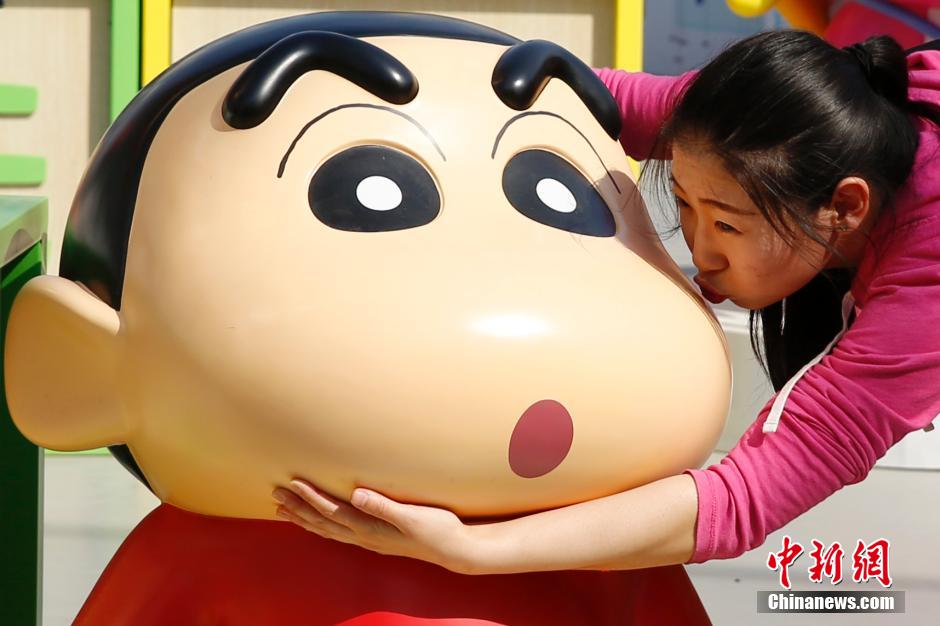 4月22日，游客與蠟筆小新合影。“蠟筆小新25周年紀(jì)念特展”日前在北京開展，吸引了不少市民游客。