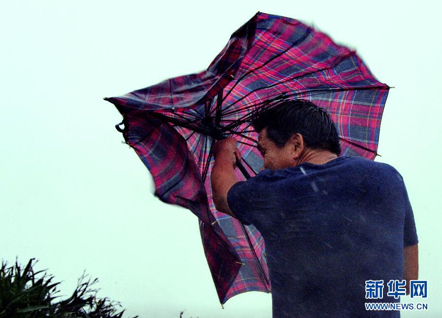 8月8日，福建省石獅市漁民在風雨中前行。