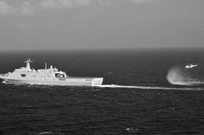 11日，抵達馬航飛機失聯海區的海軍井岡山艦與艦載直升機協同展開立體搜救行動。新華社發