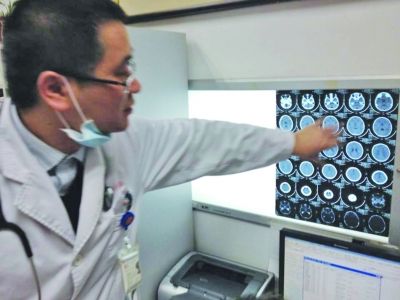 醫生在查看男孩的腦部CT片。薛馬義 攝