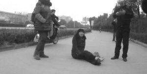 鄭大姐坐在地上，警方趕到進行施救。（視頻截圖由警方提供）