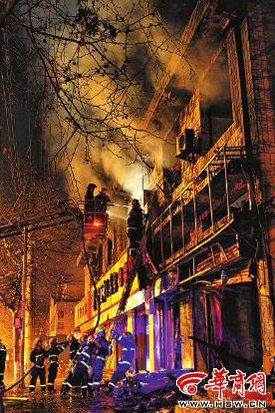 昨日22時10分，西安市豐慶路南小巷南口，消防官兵架梯子登上二樓施救 本組圖片由本報記者 閆文青 攝