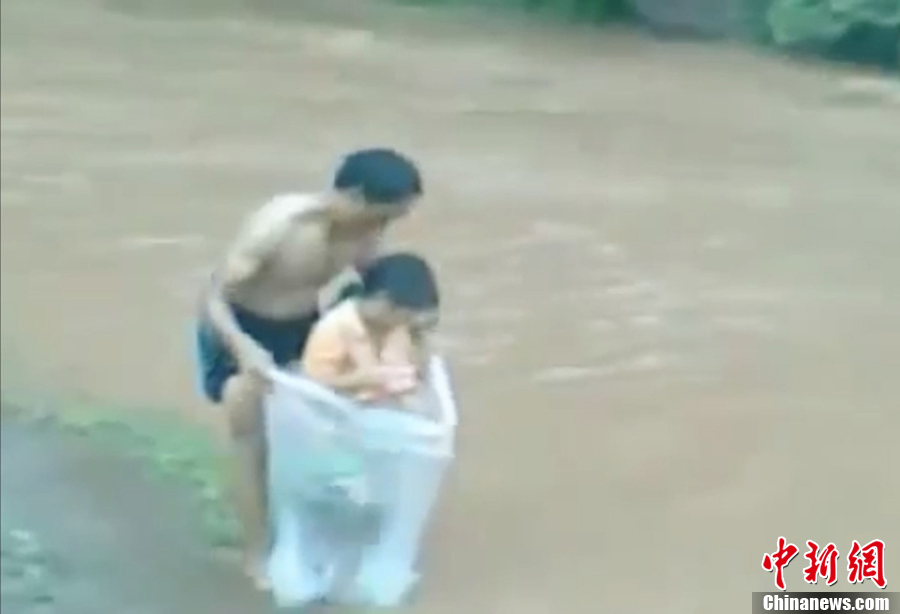 越南一村莊家長用塑料袋運孩子過河上學(xué)