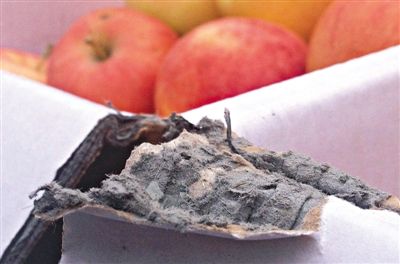 8月29日，新發(fā)地市場，一箱用“加重紙箱”包裝的蘋果正待售，紙箱夾層內灰黑色的增重填充物清晰可見