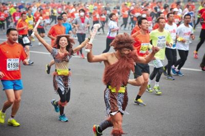 “原始人”打扮的參賽者向觀眾揮手。