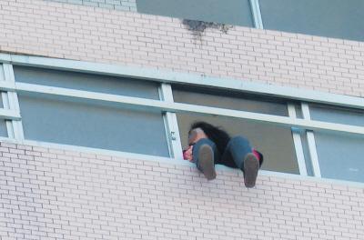 28樓的窗臺上坐著一名女子，其兩條腿耷拉在室外，不停地擺動。