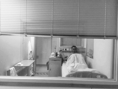 楊杰在醫(yī)院隔離病房中，沖記者揮了揮手。