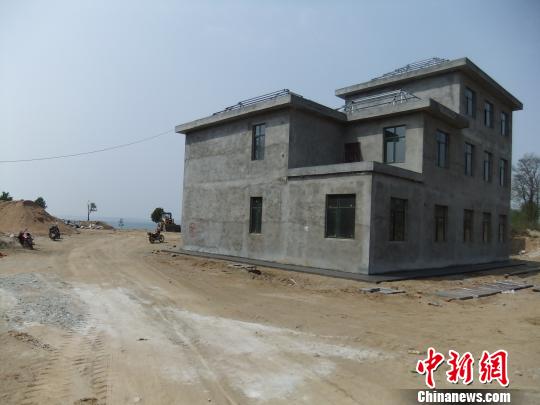 鴨河水庫庫區邊的新建別墅，一面墻上寫著“拆”，另一邊在加緊施工。吳揚　攝